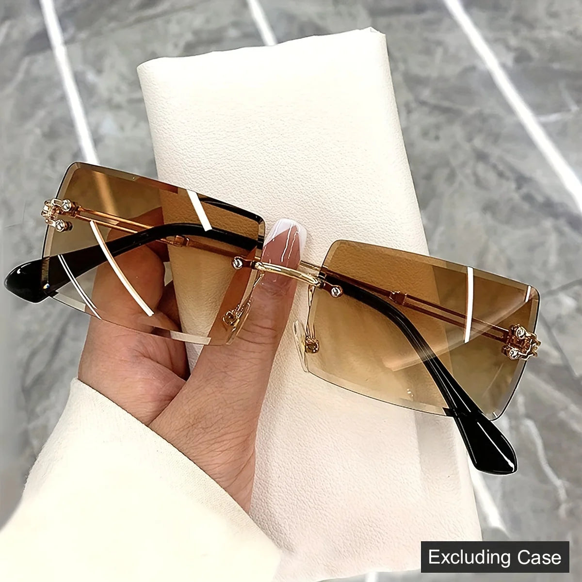 rimless, rectangular sunglasses with a brown gradient tint and decorative metal hinges.