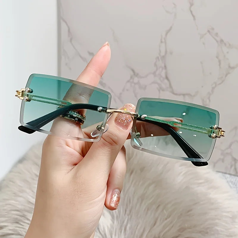 rimless, rectangular sunglasses with a brown gradient tint and decorative metal hinges.