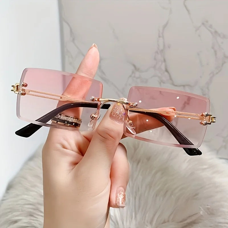 rimless, rectangular sunglasses with a brown gradient tint and decorative metal hinges.