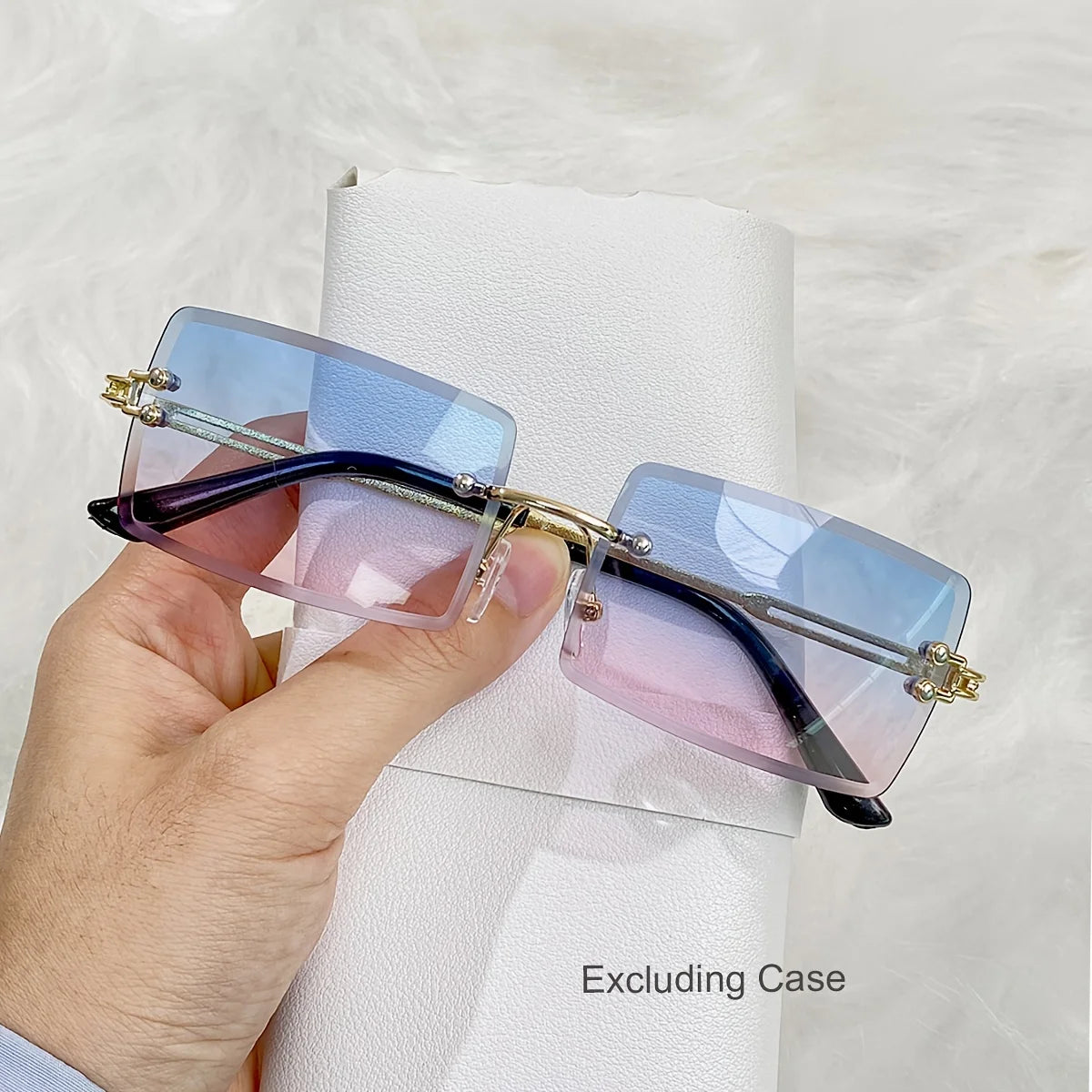 rimless, rectangular sunglasses with a brown gradient tint and decorative metal hinges.