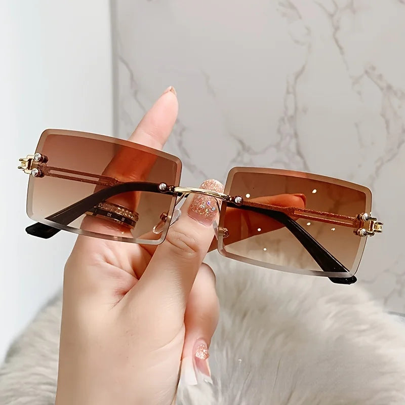 rimless, rectangular sunglasses with a brown gradient tint and decorative metal hinges.