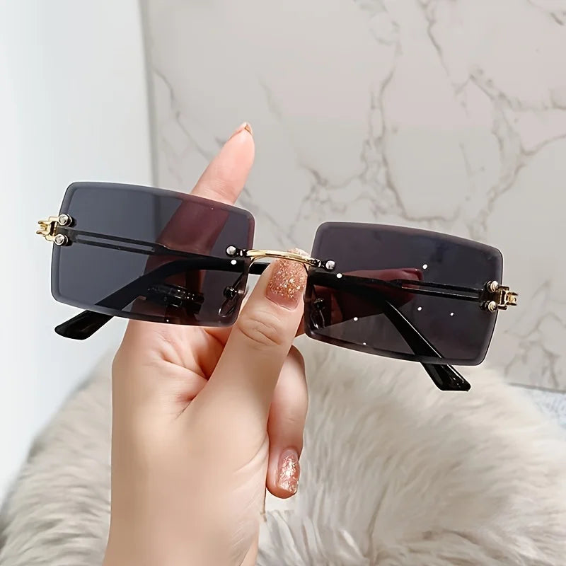 rimless, rectangular sunglasses with a brown gradient tint and decorative metal hinges.