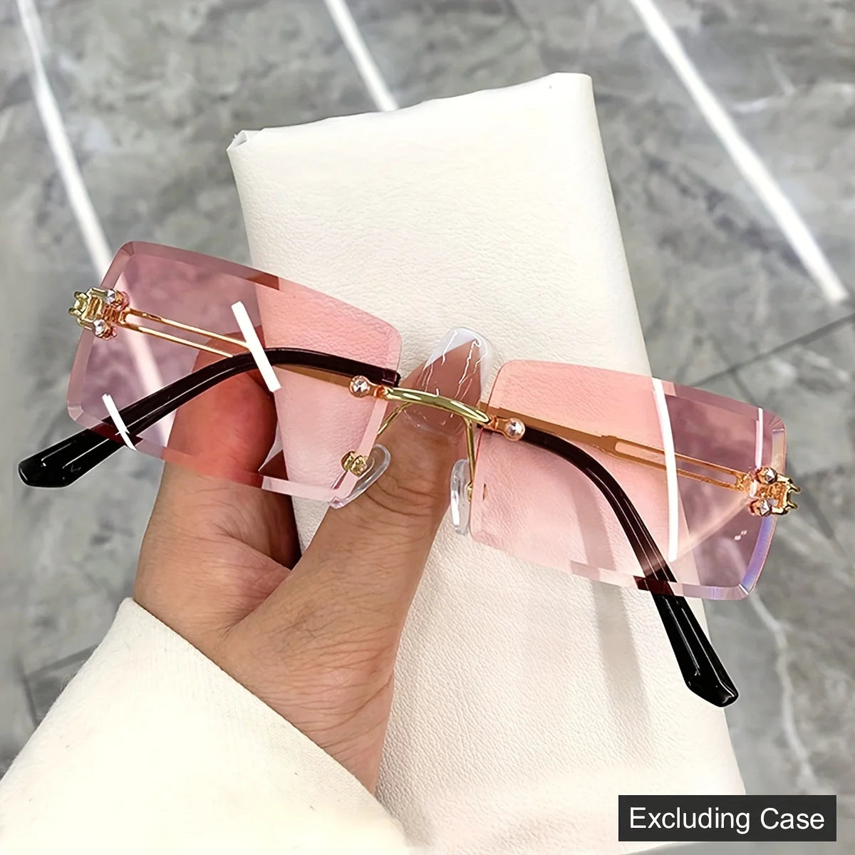 rimless, rectangular sunglasses with a brown gradient tint and decorative metal hinges.